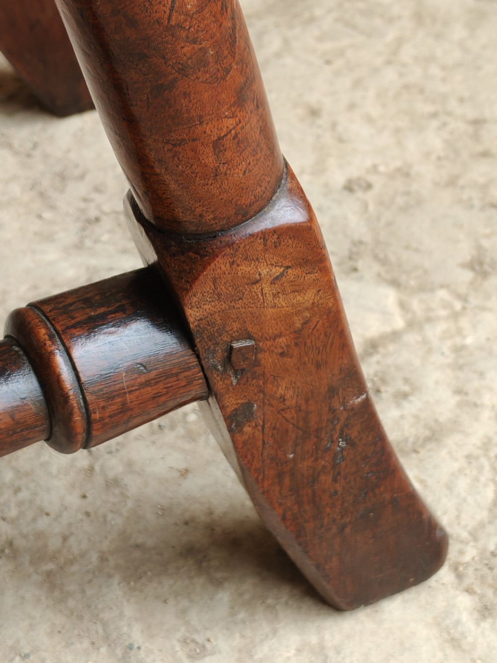 An early 18th-century walnut side chair featuring a woven cane backrest with a vertical central splat, a cane seat, turned legs, and a carved front stretcher. View IX