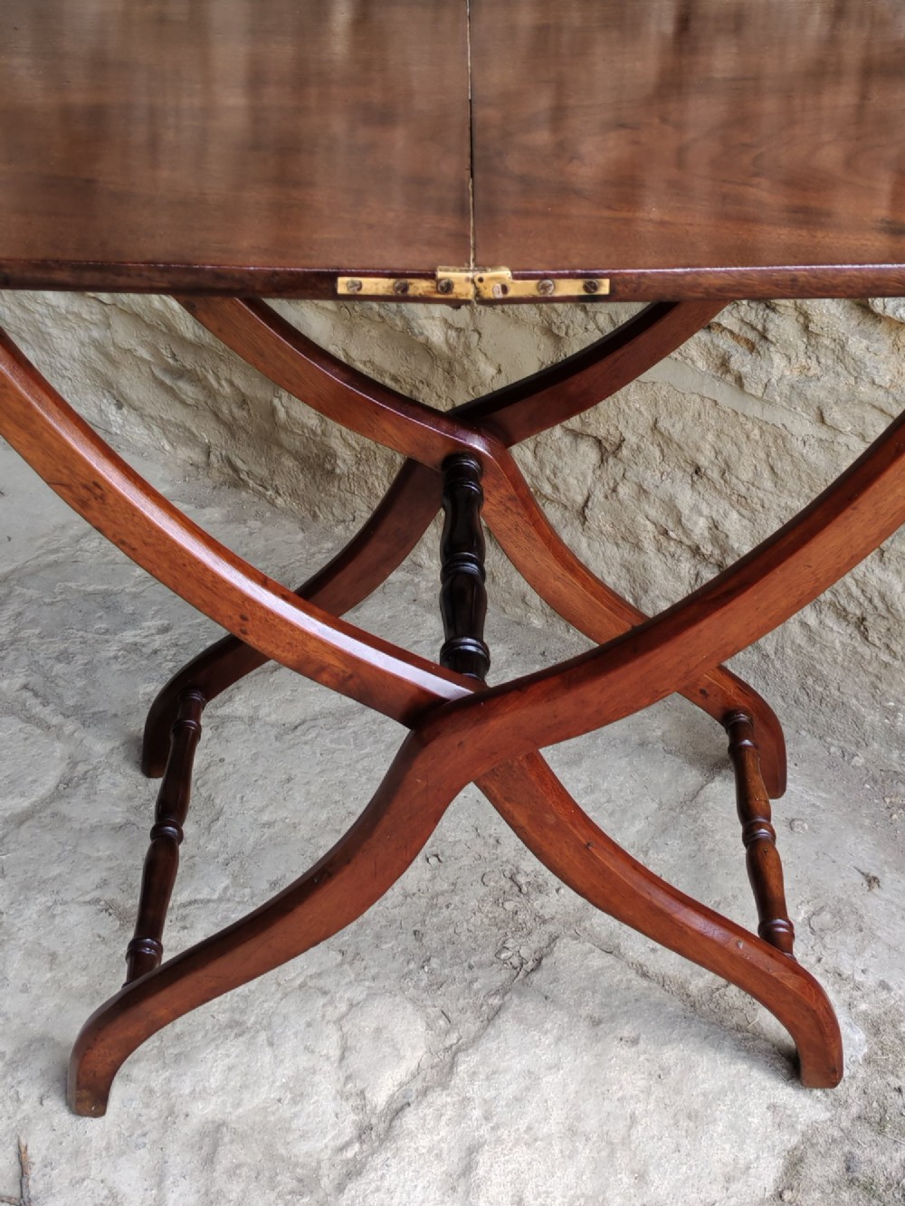 An Edwardian mahogany coaching table featuring a hinged folding rectangular top supported by curved X-frame legs and turned stretchers. View V