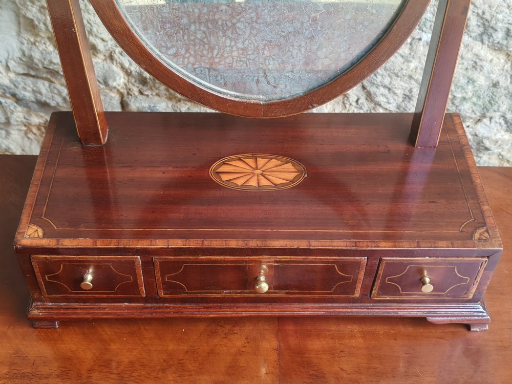 A Georgian mahogany dressing mirror featuring a shield-shaped swivel frame, bone finials, and an inlaid three-drawer box base. View III