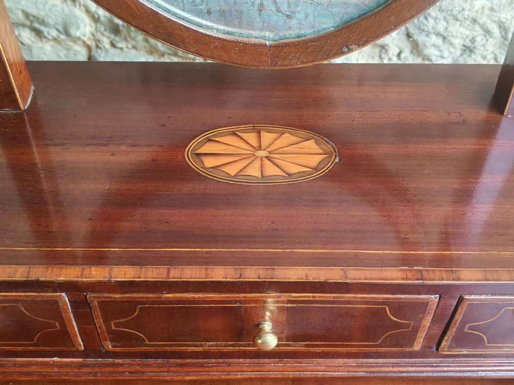 A Georgian mahogany dressing mirror featuring a shield-shaped swivel frame, bone finials, and an inlaid three-drawer box base. View IV