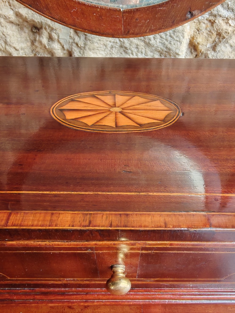 A Georgian mahogany dressing mirror featuring a shield-shaped swivel frame, bone finials, and an inlaid three-drawer box base. View V