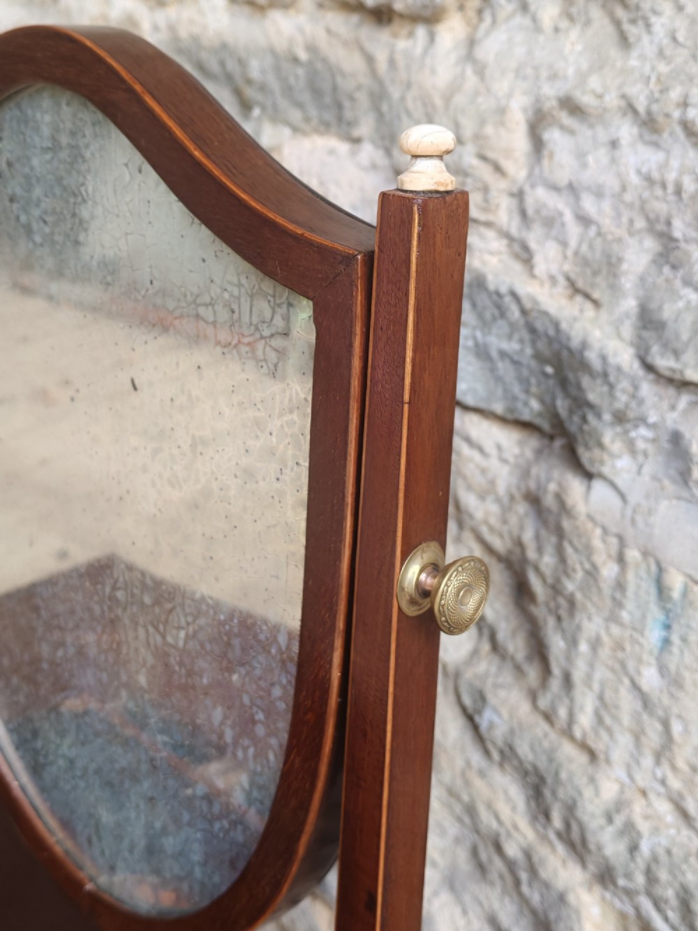 A Georgian mahogany dressing mirror featuring a shield-shaped swivel frame, bone finials, and an inlaid three-drawer box base. View VIII