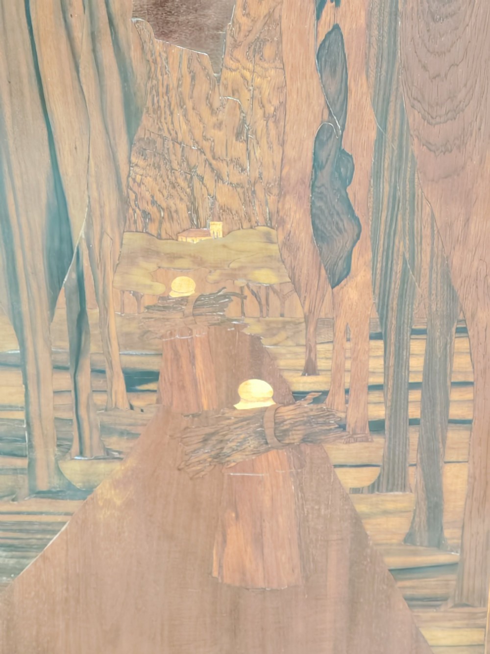A tall mahogany single-door cupboard featuring a prominent marquetry inlaid panel depicting a mountain landscape with tall trees and a central path. View VI