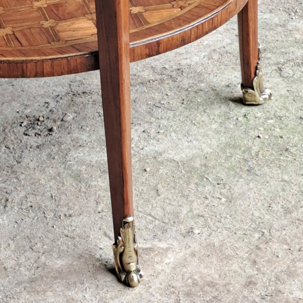 An antique circular French kingwood two-tier occasional table with geometric parquetry inlay, cabriole legs, and brass sabots. View VIII