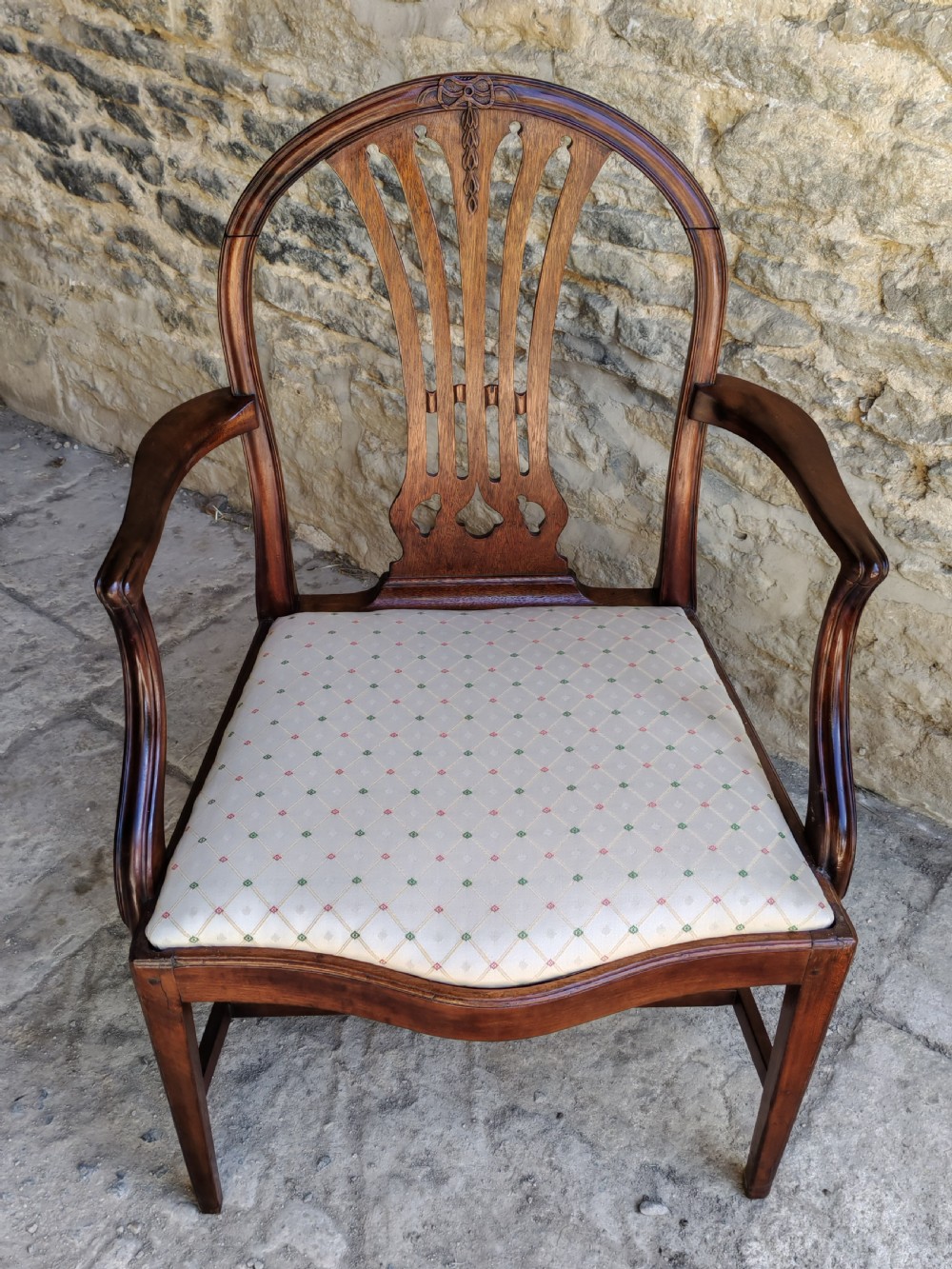 An 18th-century mahogany Hepplewhite carver armchair featuring an arched back with a pierced splat, sweeping armrests, an patterned upholstered seat, and square tapered legs. View III