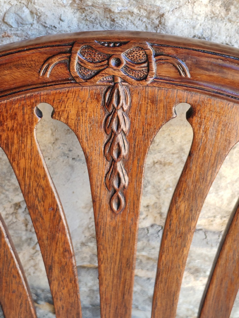 An 18th-century mahogany Hepplewhite carver armchair featuring an arched back with a pierced splat, sweeping armrests, an patterned upholstered seat, and square tapered legs. View VII