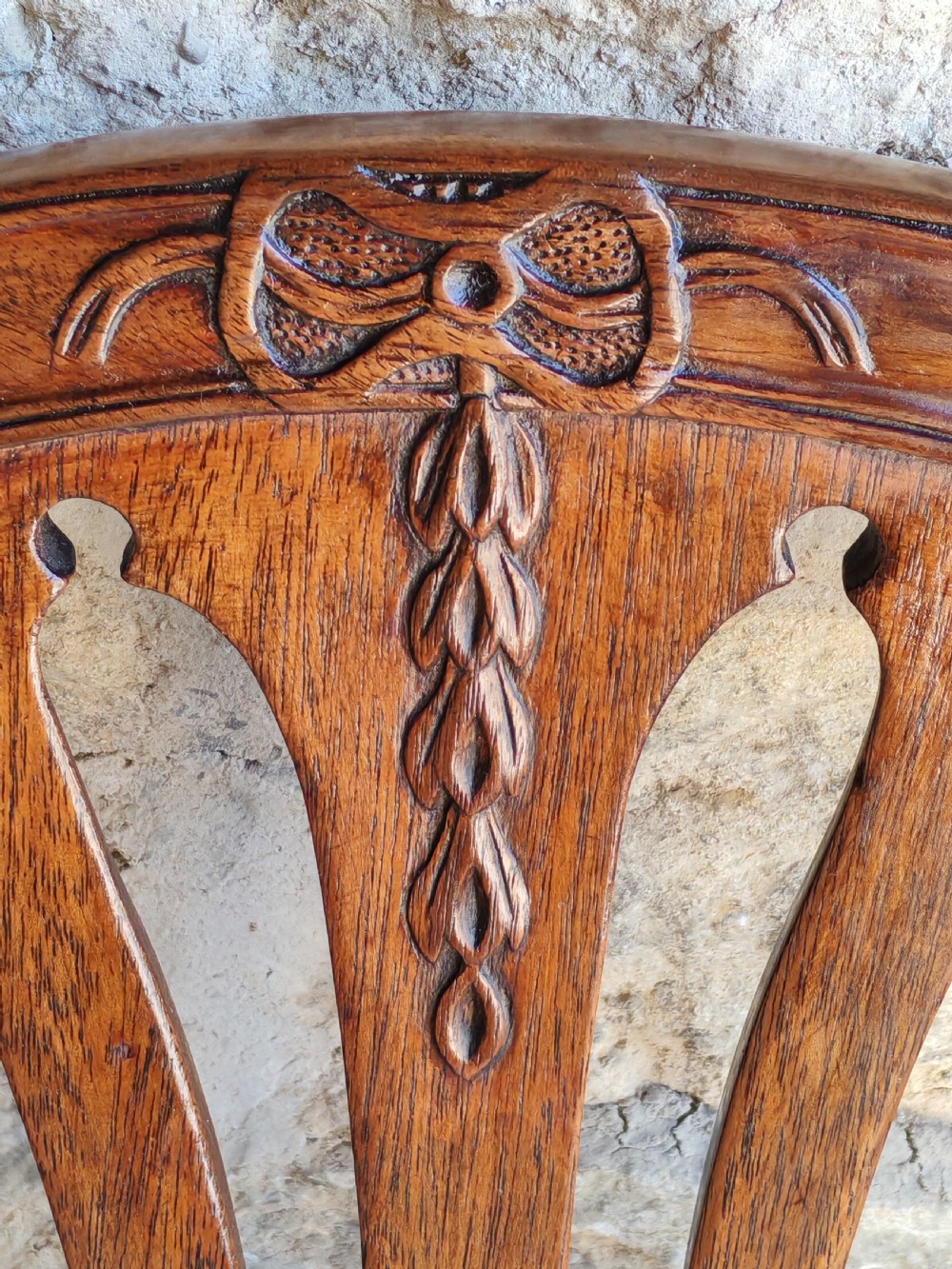 An 18th-century mahogany Hepplewhite carver armchair featuring an arched back with a pierced splat, sweeping armrests, an patterned upholstered seat, and square tapered legs. View VIII
