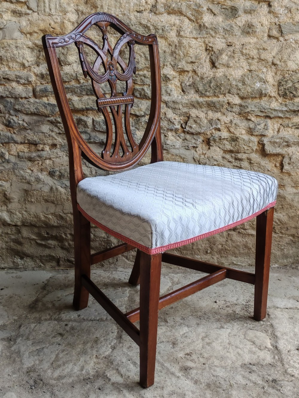 A Georgian walnut side chair featuring a carved shield backrest with openwork detailing and a patterned upholstered seat. View II