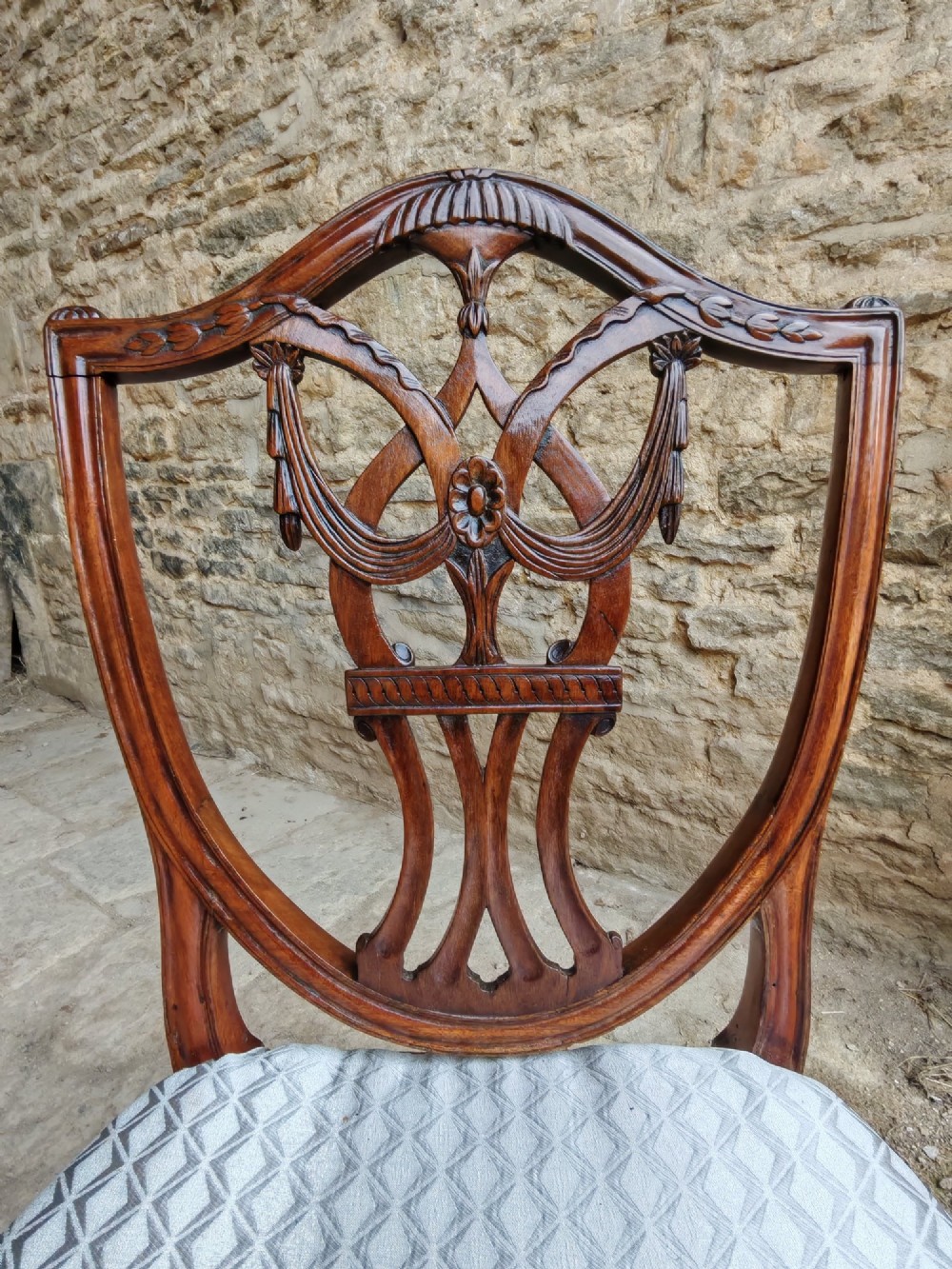 A Georgian walnut side chair featuring a carved shield backrest with openwork detailing and a patterned upholstered seat. View III