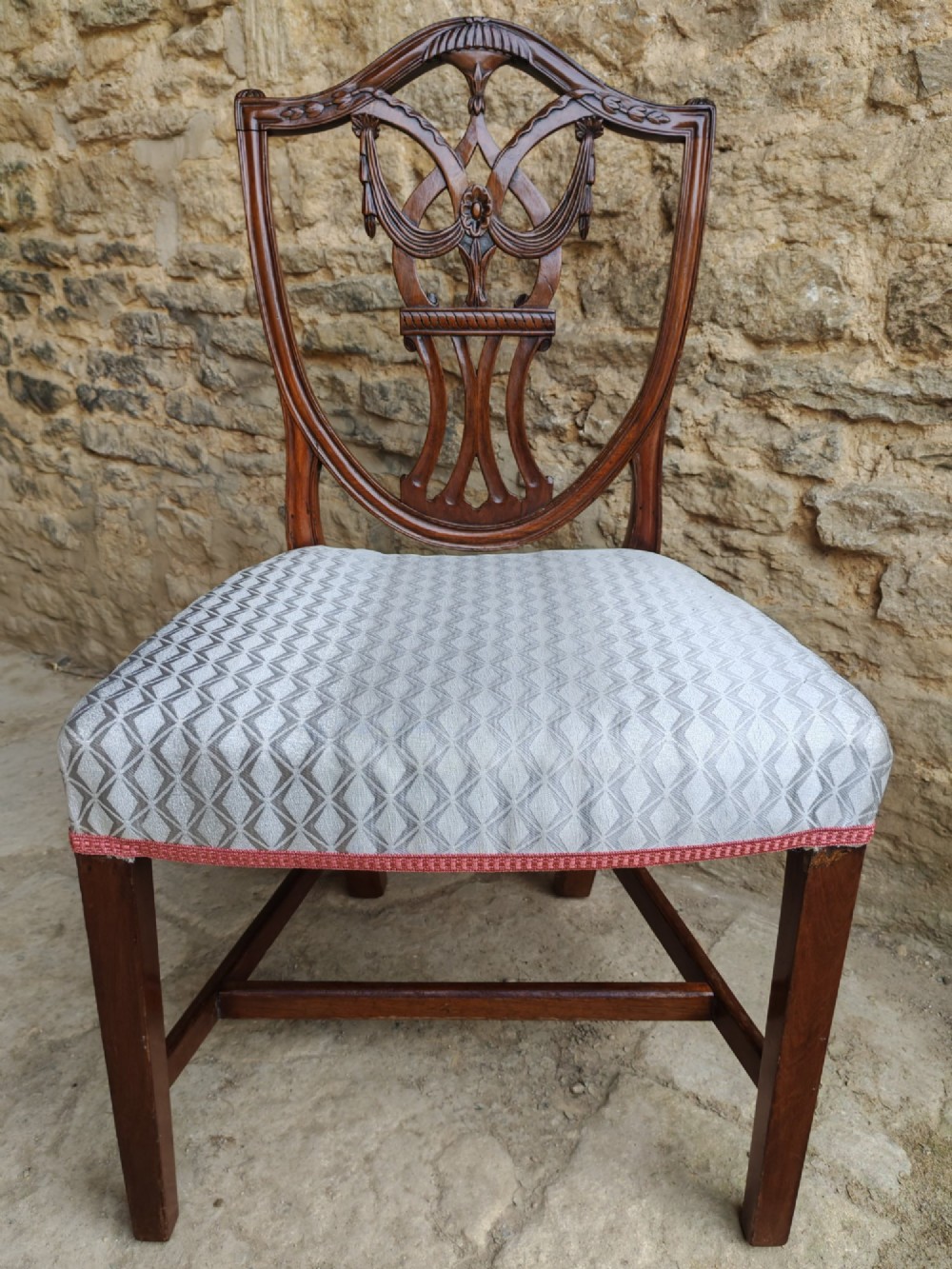 A Georgian walnut side chair featuring a carved shield backrest with openwork detailing and a patterned upholstered seat. View VII