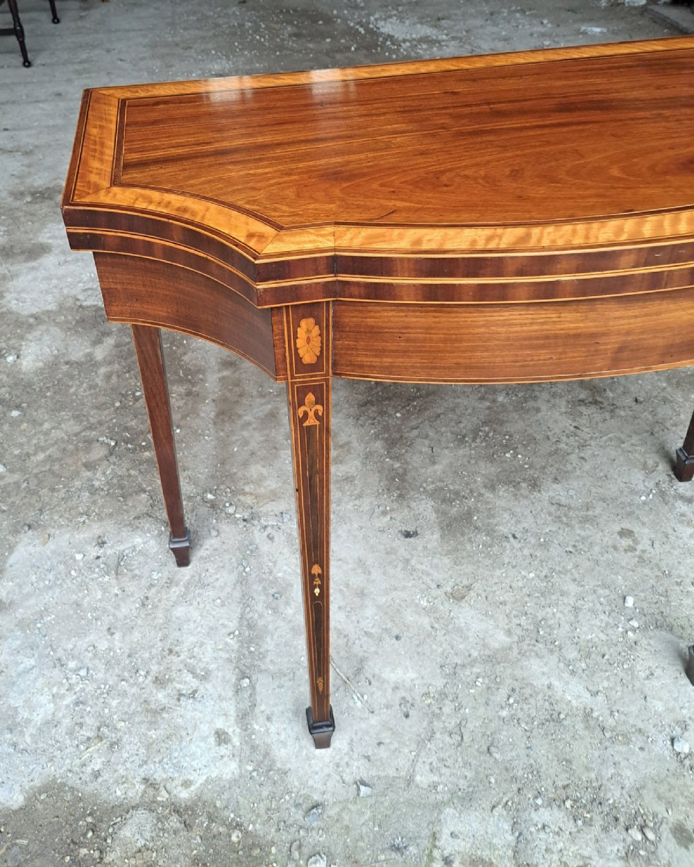 An antique late Victorian mahogany and satinwood fold-over tea table featuring a D-shaped top with satinwood crossbanding and tapered legs with floral marquetry. View VI