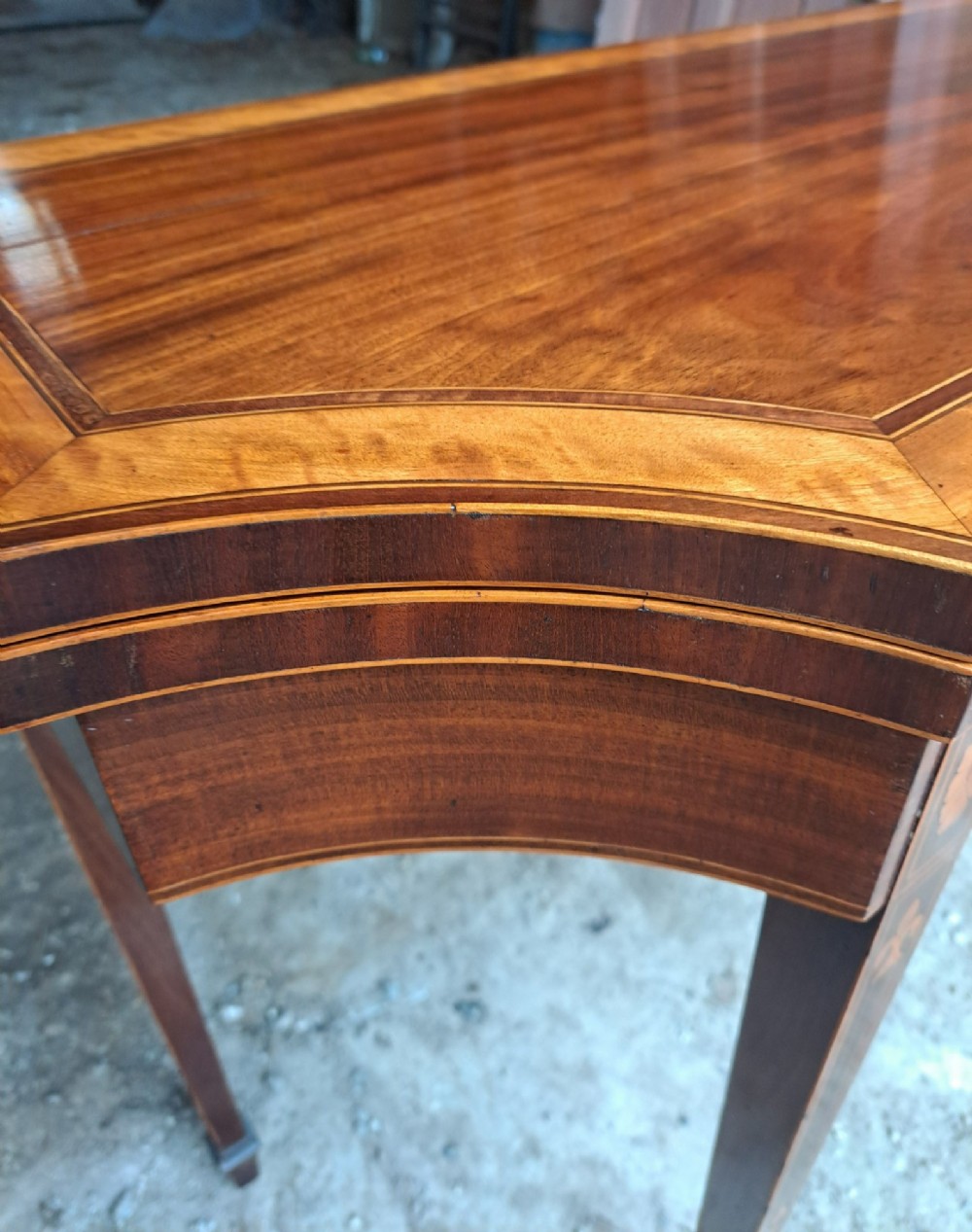 An antique late Victorian mahogany and satinwood fold-over tea table featuring a D-shaped top with satinwood crossbanding and tapered legs with floral marquetry. View VII