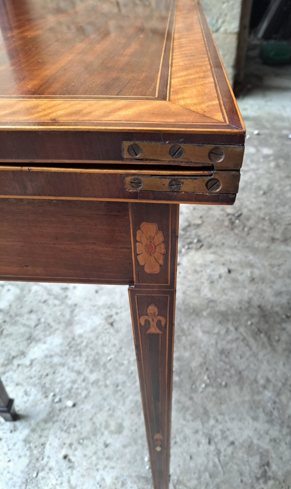 An antique late Victorian mahogany and satinwood fold-over tea table featuring a D-shaped top with satinwood crossbanding and tapered legs with floral marquetry. View VIII