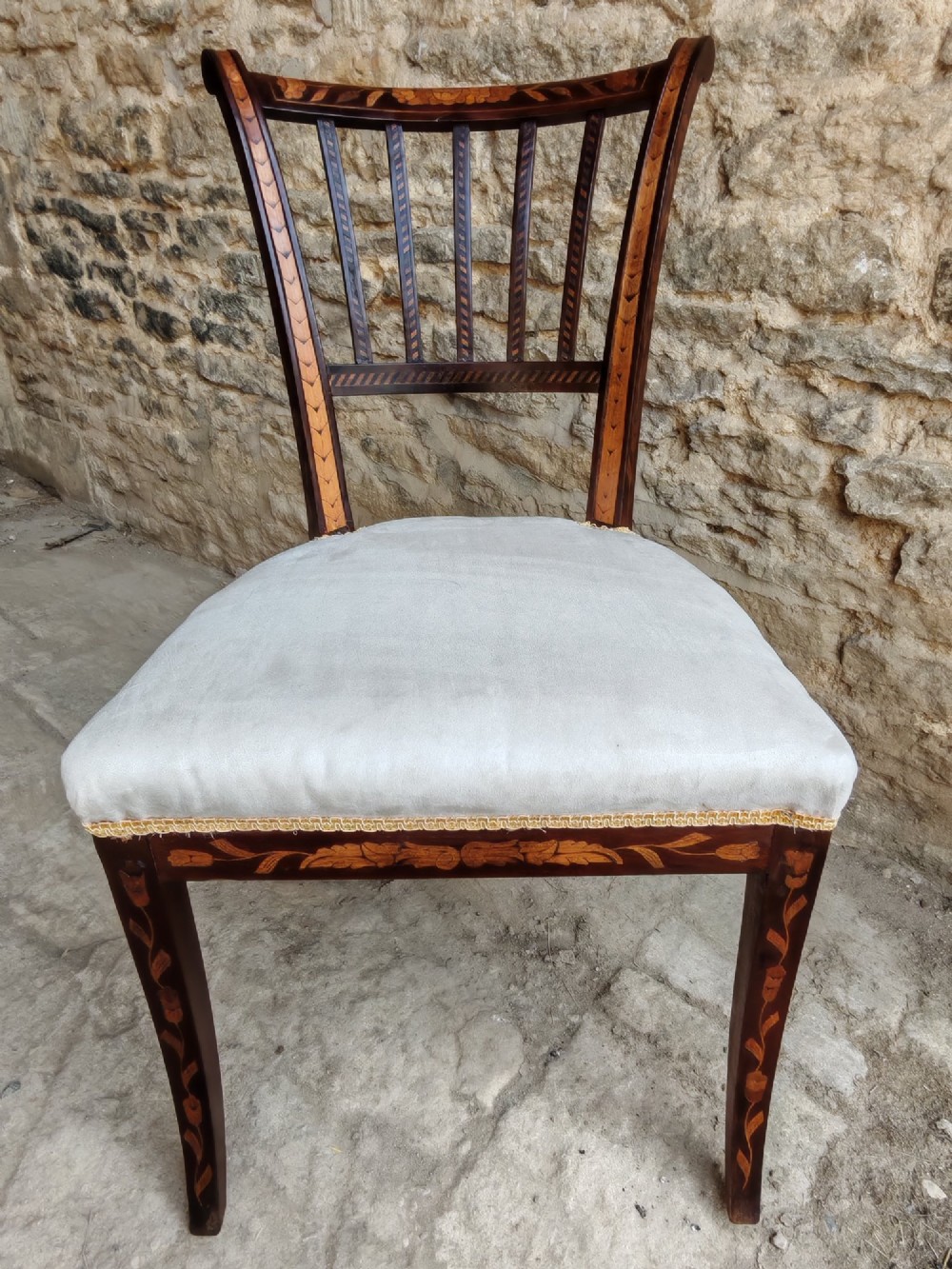 A pair of early 19th-century dark wood side chairs featuring floral marquetry inlay on the frames and light-coloured upholstered seats. View III