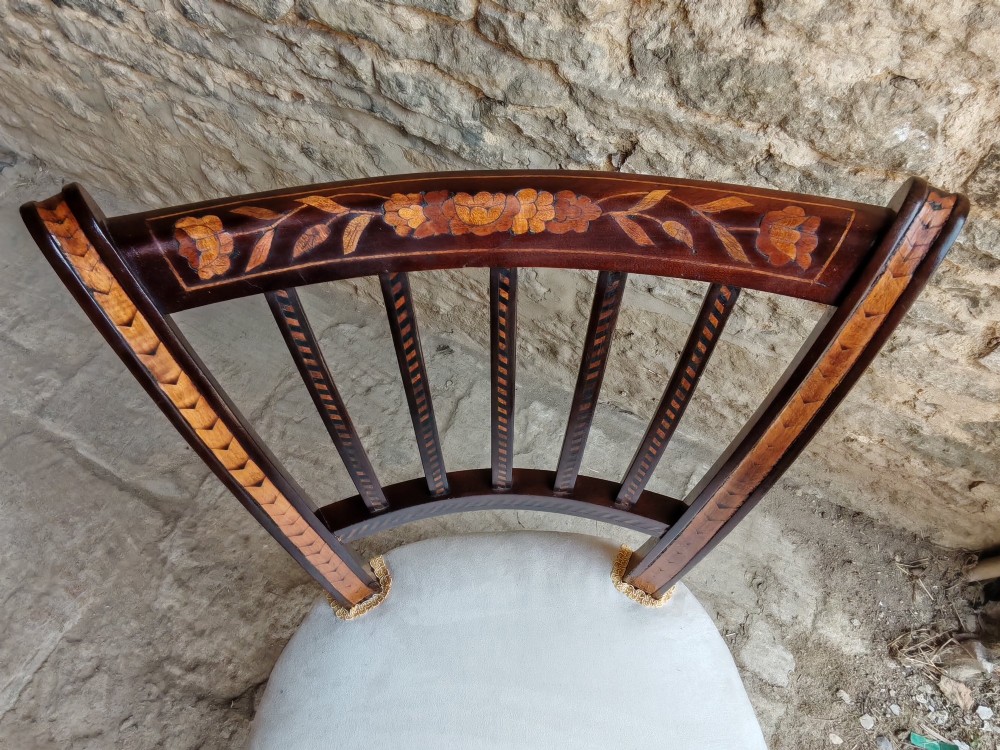 A pair of early 19th-century dark wood side chairs featuring floral marquetry inlay on the frames and light-coloured upholstered seats. View VI