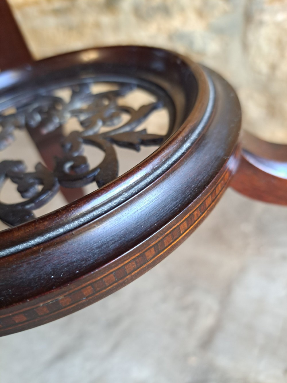 A circular mahogany occasional table featuring a central star inlay, geometric border, and sweeping sabre legs with brass castors. View VI