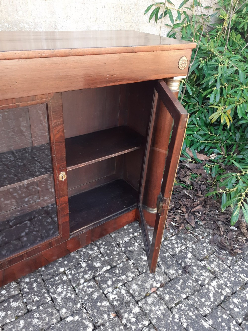 A low Regency rosewood bookcase featuring two glazed doors flanked by turned side columns with brass mounts. View VI
