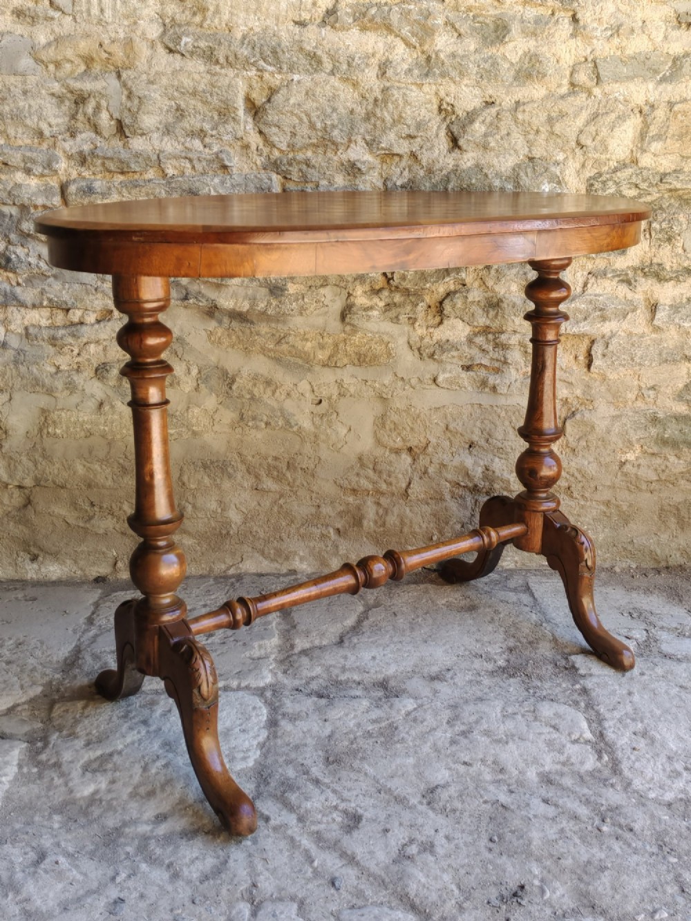 An oval walnut occasional table featuring an inlaid square chess board in the centre, supported by turned legs and a stretcher base. View IV