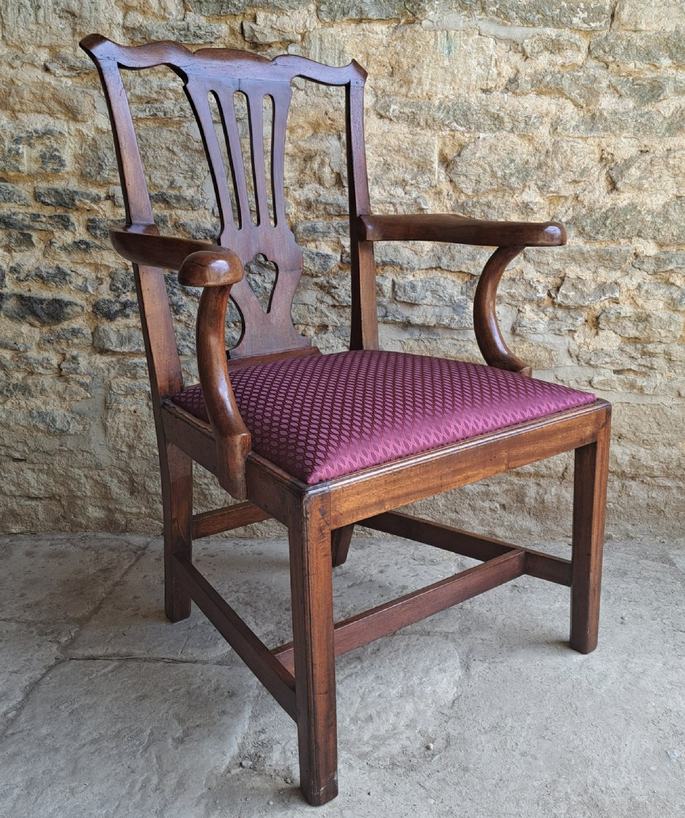 An 18th-century Irish walnut open armchair featuring a carved pierced splat, shaped armrests, an H-stretcher base, and a burgundy pattern upholstered seat. View III