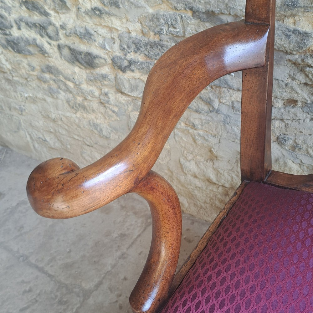An 18th-century Irish walnut open armchair featuring a carved pierced splat, shaped armrests, an H-stretcher base, and a burgundy pattern upholstered seat. View VII