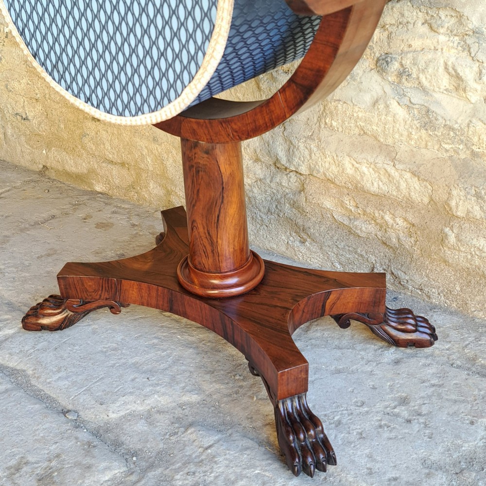 An antique rosewood drop-leaf sewing table with a central drawer, a suspended patterned fabric basket, a turned pedestal column, and carved claw feet. View V