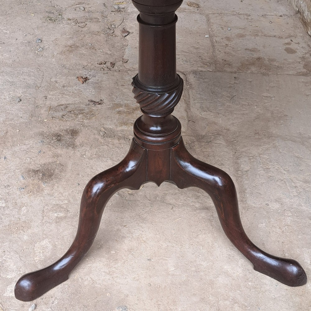 An 18th-century Georgian mahogany tilt-top table featuring a circular top, turned central column with a spirally carved knop, and three cabriole legs ending in pad feet. View IV