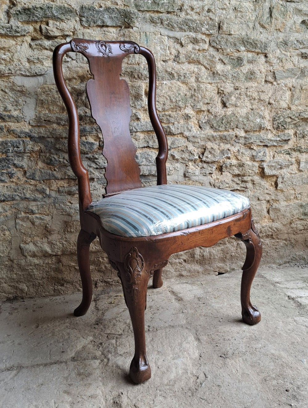 An 18th-century red walnut side chair with a shaped splat back, striped upholstered seat, and carved cabriole legs. View II