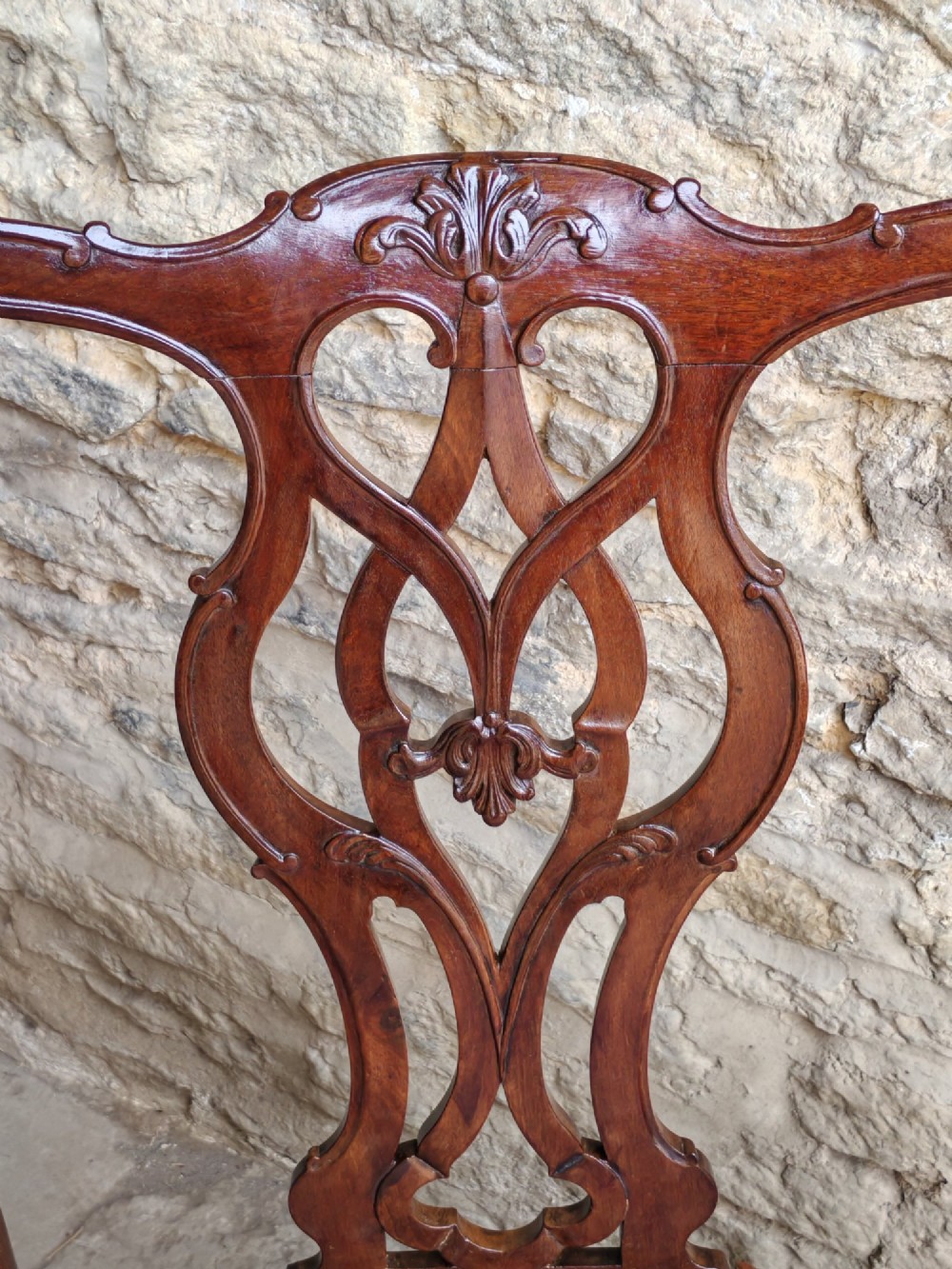 A Georgian mahogany carver armchair featuring a pierced back splat, shaped arms, square carved front legs, and geometric patterned fabric seating. View V