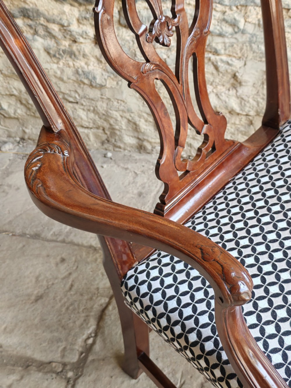 A Georgian mahogany carver armchair featuring a pierced back splat, shaped arms, square carved front legs, and geometric patterned fabric seating. View VI