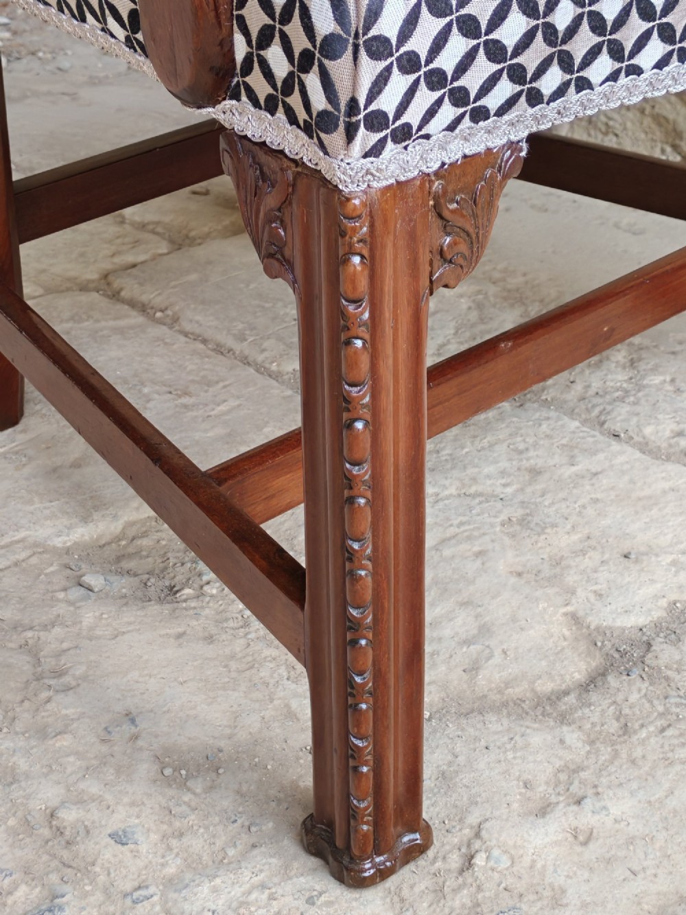 A Georgian mahogany carver armchair featuring a pierced back splat, shaped arms, square carved front legs, and geometric patterned fabric seating. View VII