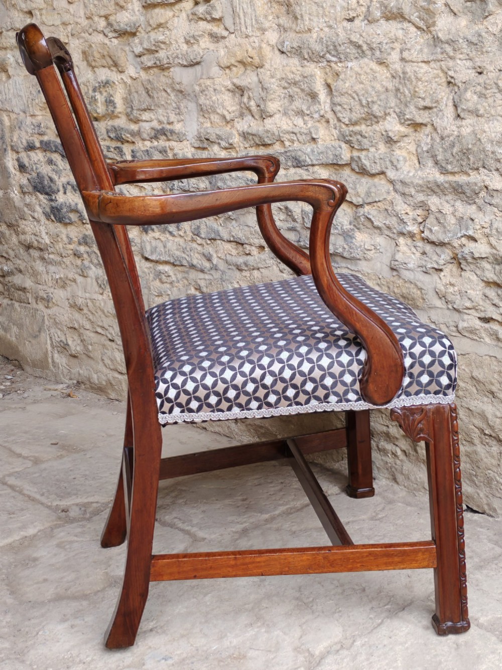 A Georgian mahogany carver armchair featuring a pierced back splat, shaped arms, square carved front legs, and geometric patterned fabric seating. View VIII