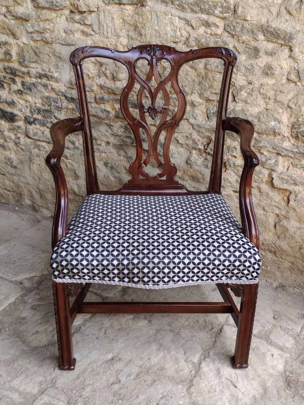A Georgian mahogany carver armchair featuring a pierced back splat, shaped arms, square carved front legs, and geometric patterned fabric seating. View IX