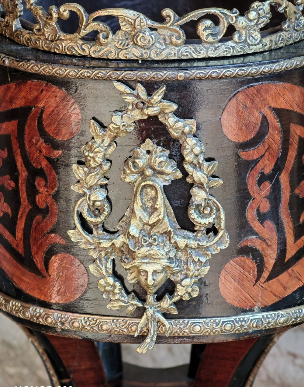 A 19th-century French marquetry jardiniere table with intricate wood inlay, ornate gilded mounts, a cherub porcelain plaque, and cabriole legs. View IV