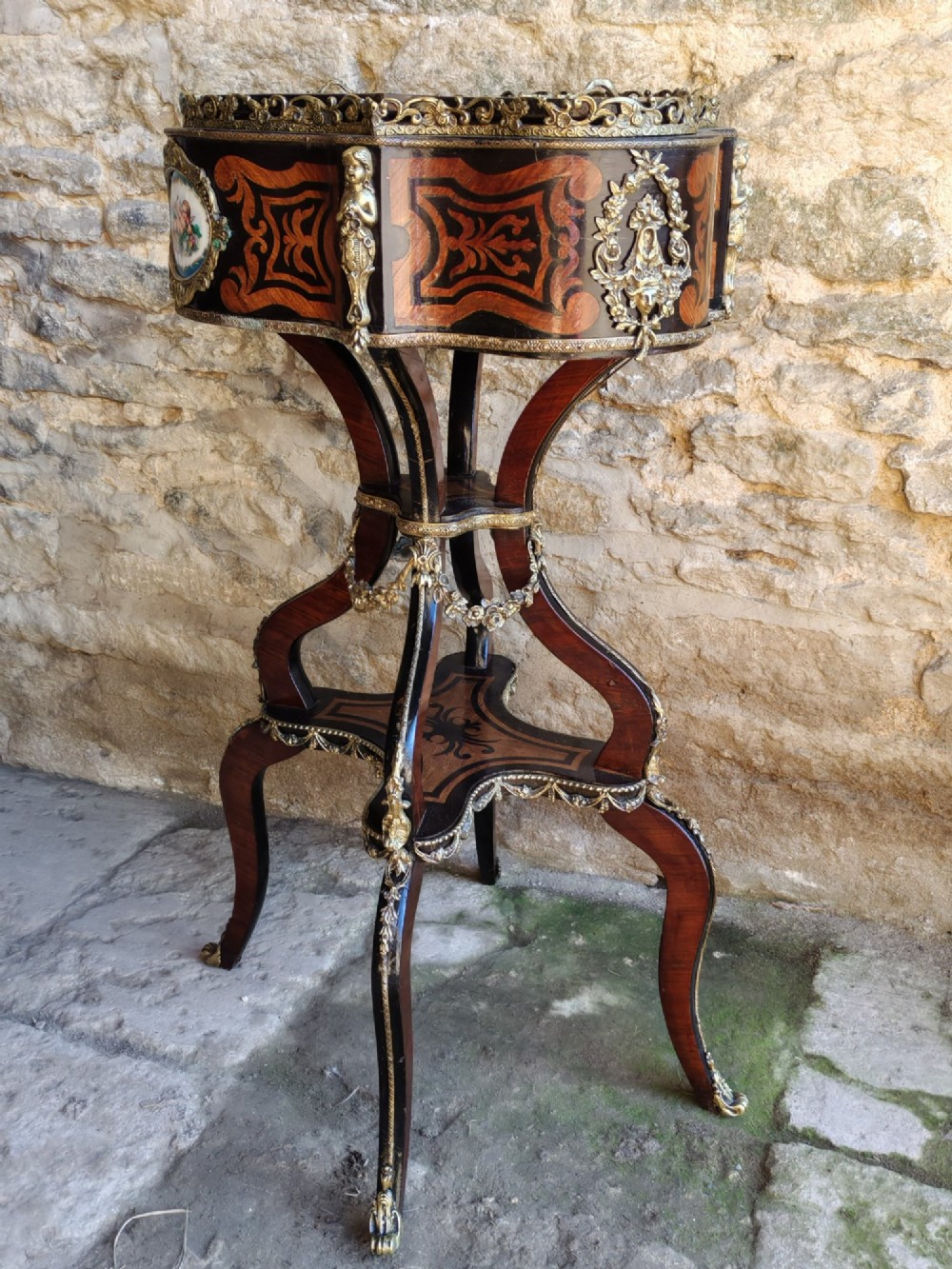 A 19th-century French marquetry jardiniere table with intricate wood inlay, ornate gilded mounts, a cherub porcelain plaque, and cabriole legs. View VII