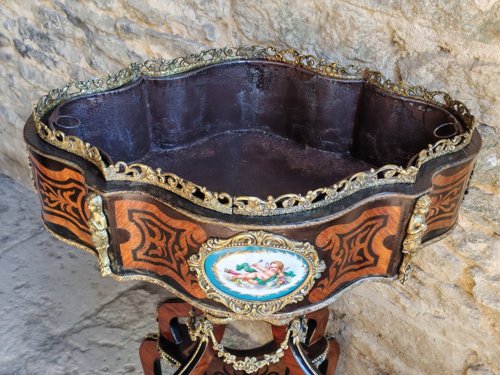 A 19th-century French marquetry jardiniere table with intricate wood inlay, ornate gilded mounts, a cherub porcelain plaque, and cabriole legs. View IX