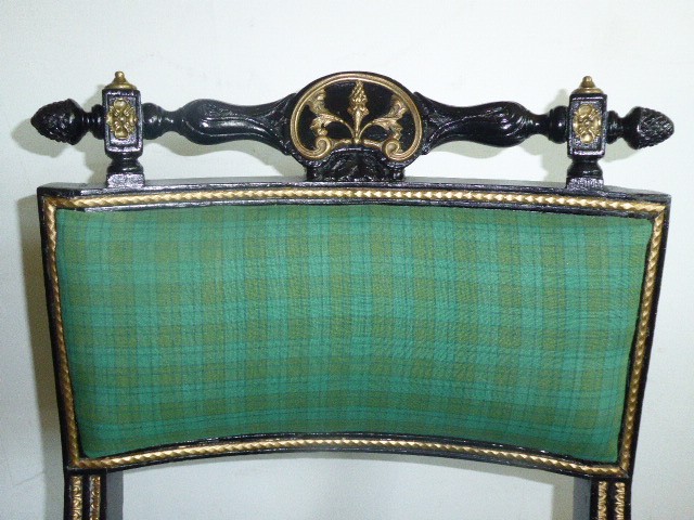 A set of four ebonised and parcel-gilt Regency side chairs featuring curved sabre legs, carved top rails, and vibrant green upholstered seats. View VII