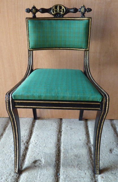 A set of four ebonised and parcel-gilt Regency side chairs featuring curved sabre legs, carved top rails, and vibrant green upholstered seats. View VIII