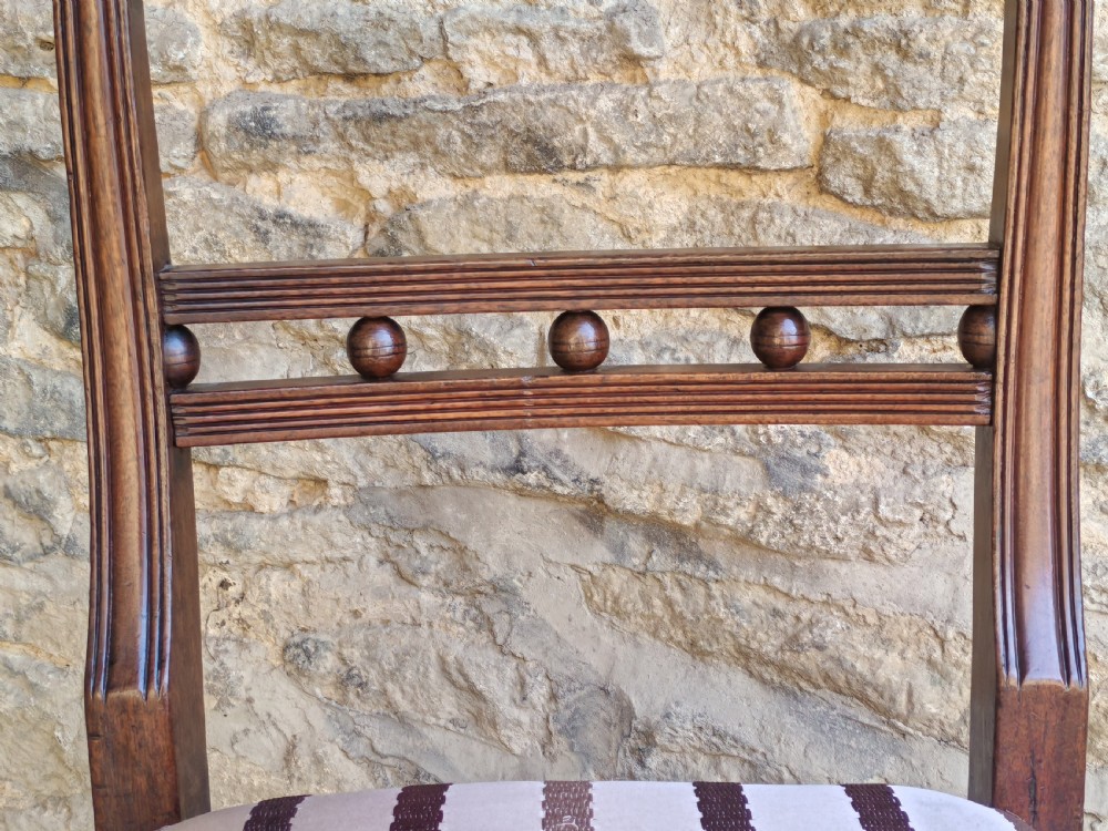 A pair of antique mahogany side chairs featuring reeded frames, a ball-ornamented mid-rail, and striped upholstered seats. View V