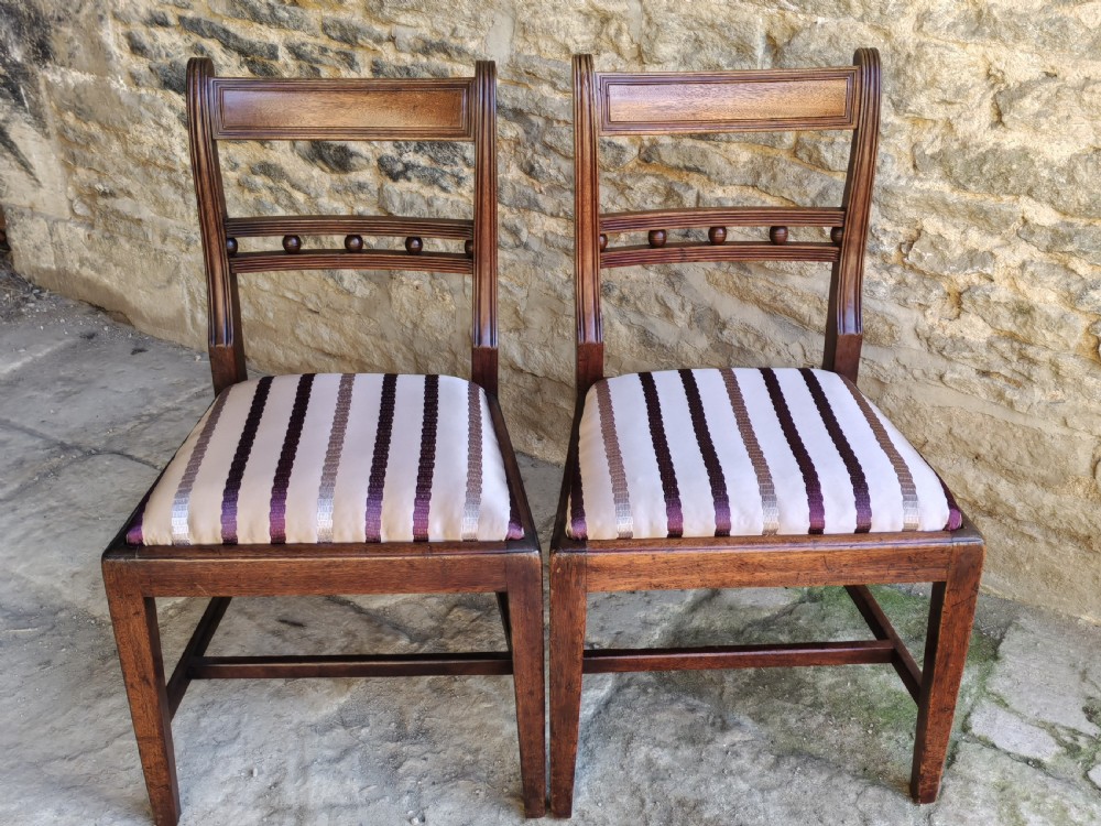 A pair of antique mahogany side chairs featuring reeded frames, a ball-ornamented mid-rail, and striped upholstered seats. View VI
