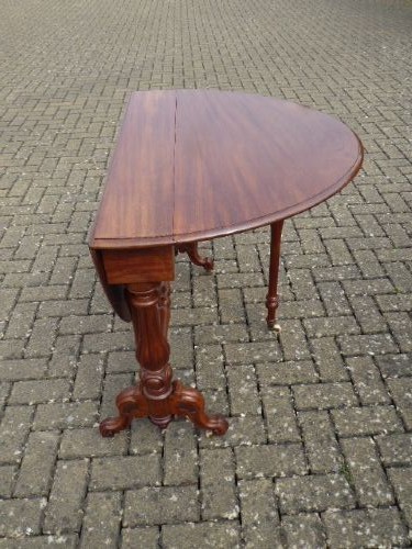 A Victorian solid walnut Sutherland table with folded drop leaves, turned baluster supports, and ceramic castors. View IV