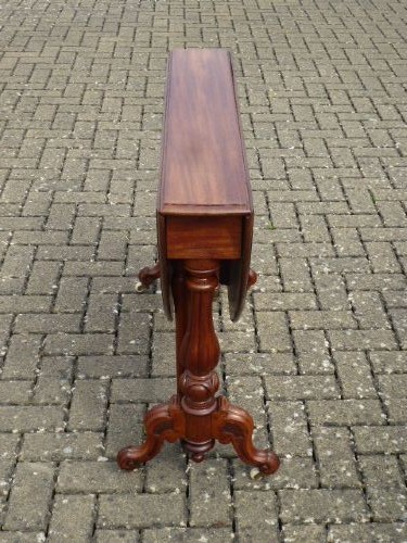 A Victorian solid walnut Sutherland table with folded drop leaves, turned baluster supports, and ceramic castors. View II