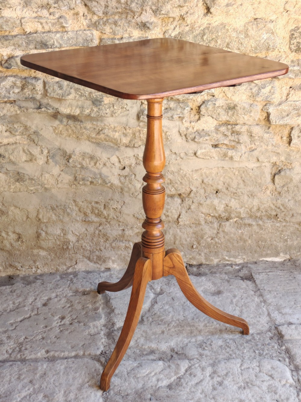 A square top antique fruitwood wine table featuring rounded corners, a central turned baluster stem, and three splayed tripod legs. View III