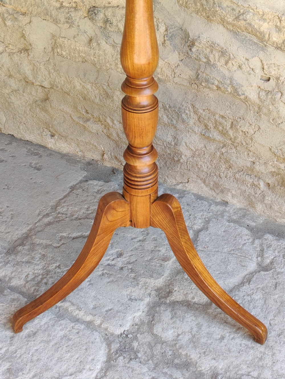 A square top antique fruitwood wine table featuring rounded corners, a central turned baluster stem, and three splayed tripod legs. View V