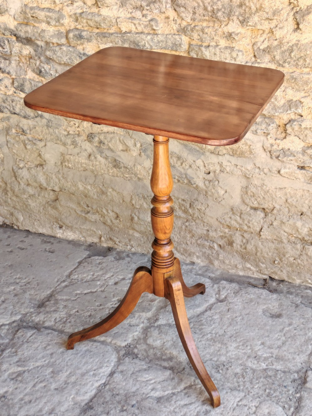 A square top antique fruitwood wine table featuring rounded corners, a central turned baluster stem, and three splayed tripod legs. View VIII