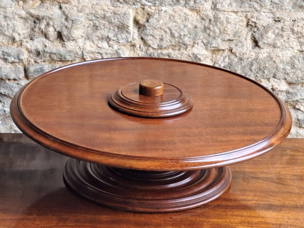 A circular Victorian mahogany Lazy Susan featuring a tiered pedestal base and central turned knob. View V