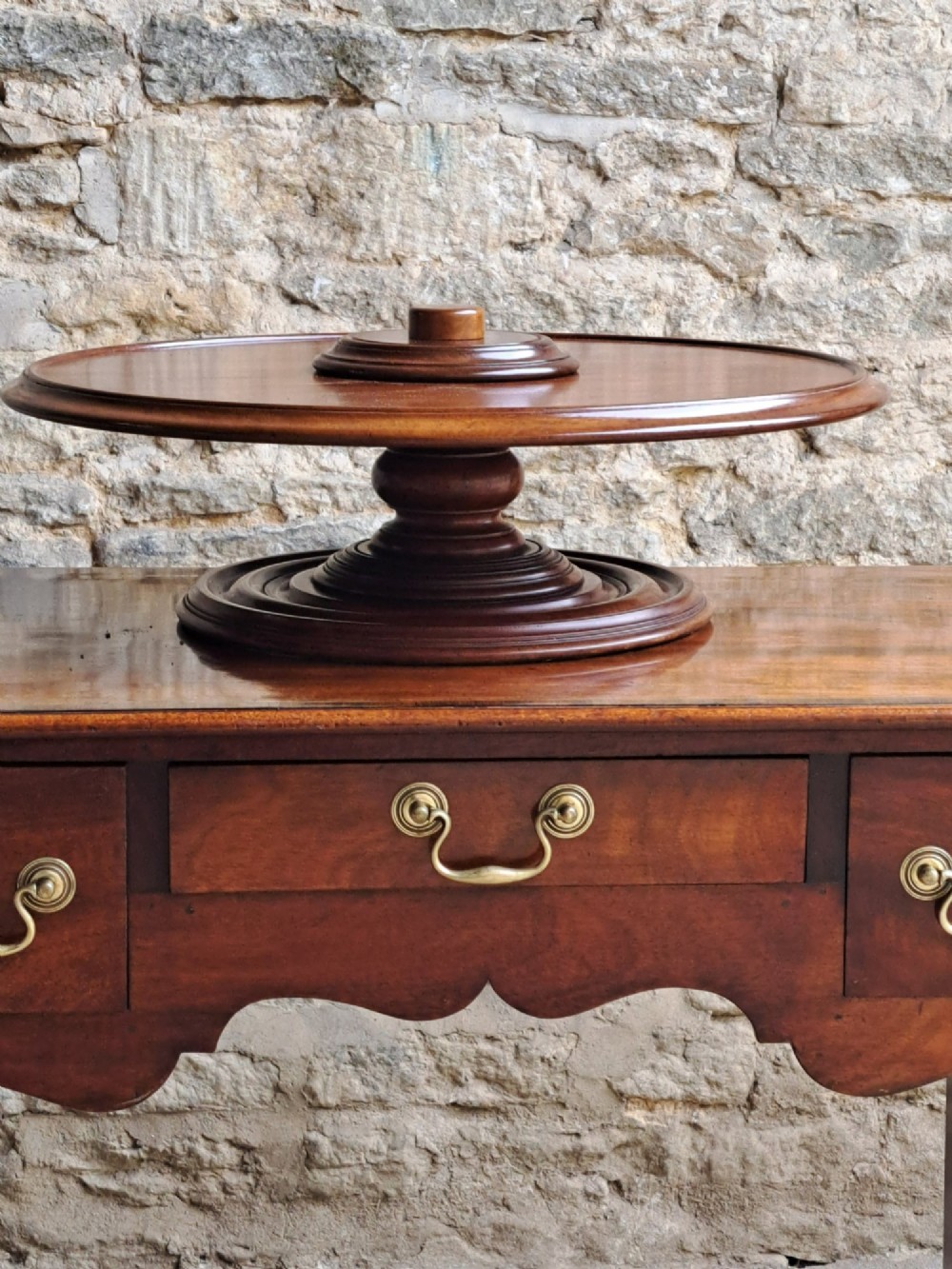 A circular Victorian mahogany Lazy Susan featuring a tiered pedestal base and central turned knob. View VI