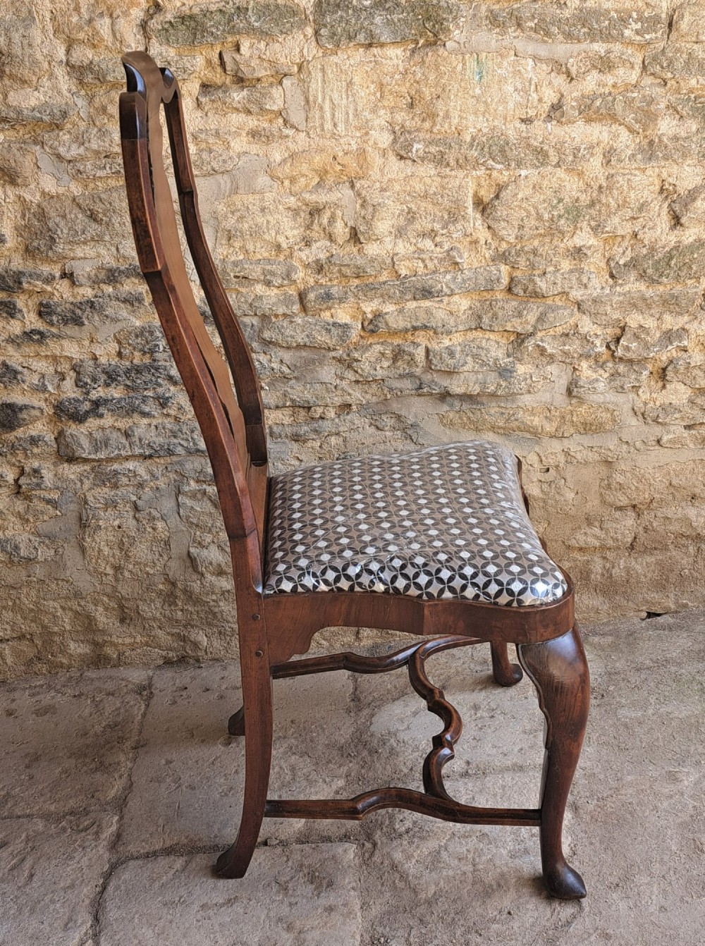A Queen Anne walnut side chair featuring a shaped vase back splat, patterned drop-in seat, and cabriole front legs with pad feet. View III