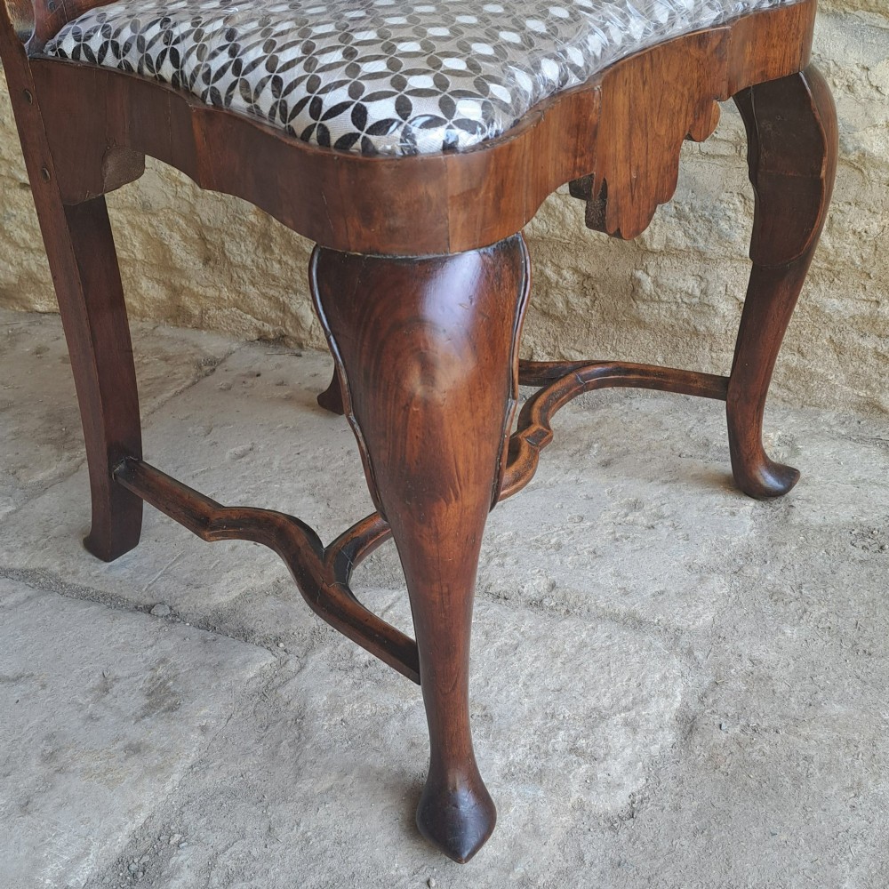 A Queen Anne walnut side chair featuring a shaped vase back splat, patterned drop-in seat, and cabriole front legs with pad feet. View VI