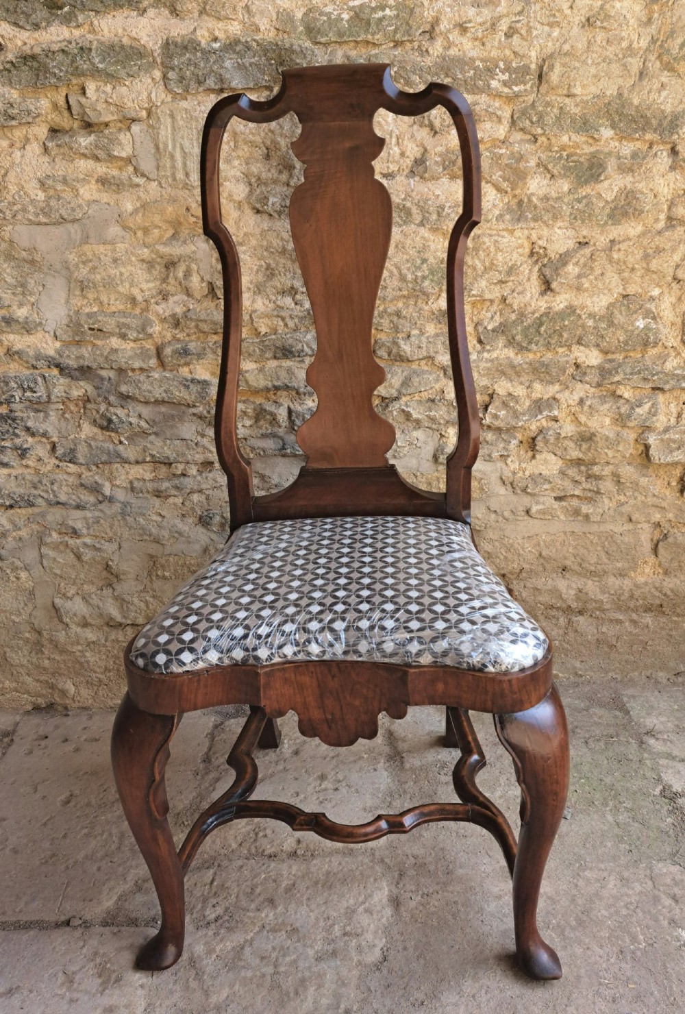 A Queen Anne walnut side chair featuring a shaped vase back splat, patterned drop-in seat, and cabriole front legs with pad feet. View VII