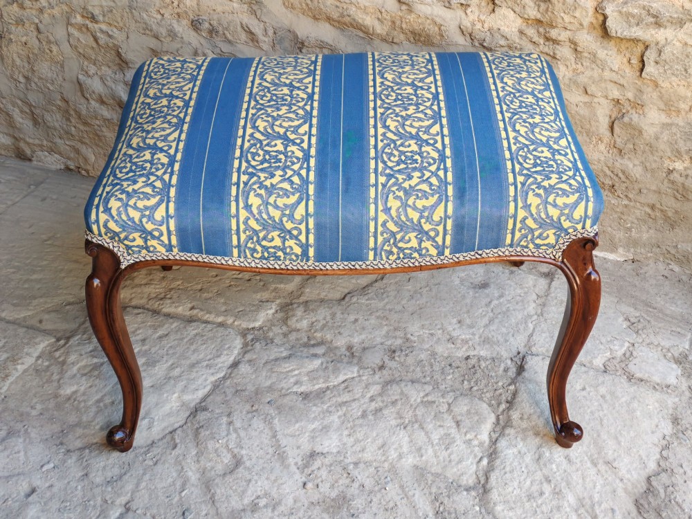 An antique walnut stool featuring carved cabriole legs and a patterned blue and yellow striped upholstered top with gimp trim. View II